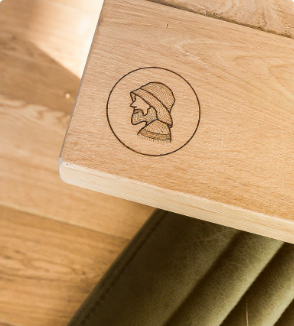 Een logo gegraveerd op een houten tafelblad in een restaurant.