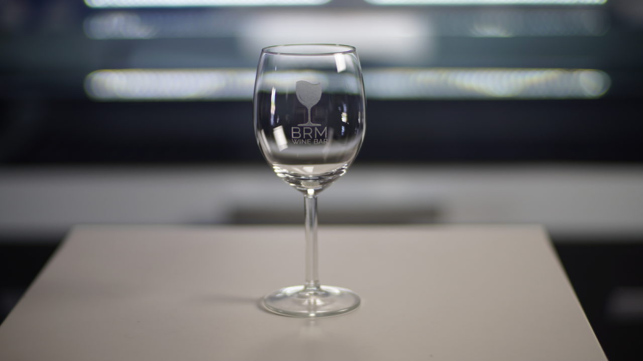 Een lasergegraveerd glas met een logo van een bar erop.